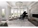 Bright living room featuring a grand piano, fireplace, and large windows at 12640 Hearthstone Way, Alpharetta, GA 30009