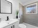 Bathroom featuring tiled shower and modern vanity with black hardware and bright natural light at 6650 Baldwin Ct, Riverdale, GA 30274