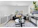 Bright living room with white walls, dark sofa, round table, and neutral color palette decor at 6650 Baldwin Ct, Riverdale, GA 30274