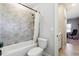 Bright bathroom featuring a shower-tub combo with gray tiles and neutral paint at 3836 Alice Ln, Suwanee, GA 30024