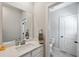 Clean bathroom featuring a white vanity, large mirror, and a toilet in the adjacent room at 3836 Alice Ln, Suwanee, GA 30024