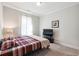 Cozy bedroom featuring plush carpet, neutral walls, and a window providing natural light at 3836 Alice Ln, Suwanee, GA 30024