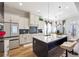 Open-concept kitchen featuring a center island, bar stools, and stainless steel refrigerator at 3836 Alice Ln, Suwanee, GA 30024