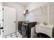 Bright laundry room with decorative floor tiles, modern washer and dryer and a stainless utility sink at 3836 Alice Ln, Suwanee, GA 30024