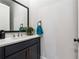 Stylish powder room with a modern vanity, quartz countertop, and decorative mirror at 3836 Alice Ln, Suwanee, GA 30024