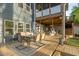Inviting back deck with dining area, hanging chairs, and comfortable seating under covered patio at 551 Rokeby Dr, Woodstock, GA 30188