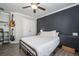 Well lit bedroom featuring hard wood floors, black accent wall, ceiling fan, and guitar decoration at 551 Rokeby Dr, Woodstock, GA 30188