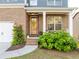 Inviting front porch with a decorative glass door, brick accents, and lush landscaping at 551 Rokeby Dr, Woodstock, GA 30188