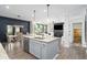 Open kitchen featuring a large island, modern appliances, pendant lighting, and views into the living area at 551 Rokeby Dr, Woodstock, GA 30188