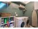 Well-organized laundry room with white washer and dryer, shelving, and plenty of storage space at 551 Rokeby Dr, Woodstock, GA 30188