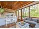 Inviting screened-in porch with a full outdoor kitchen, comfortable seating, and a cozy gas fireplace at 551 Rokeby Dr, Woodstock, GA 30188