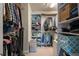 Organized walk-in closet with shelving and hanging storage for clothes and accessories at 551 Rokeby Dr, Woodstock, GA 30188