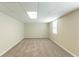 This carpeted basement features neutral paint, a drop ceiling, and a bright window at 1059 Buckboard Ct, Douglasville, GA 30134