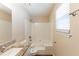 Bathroom featuring a tub with shower, window, and a granite countertop on the vanity at 1059 Buckboard Ct, Douglasville, GA 30134