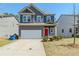 Charming two-story home with a gray facade, red front door, and attached two-car garage at 169 Parkview Place Dr, Mcdonough, GA 30253