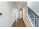 Inviting hallway with hardwood floors, white doors, staircase with decorative iron spindles at 169 Parkview Place Dr, Mcdonough, GA 30253