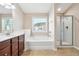 Bright bathroom showcasing a soaking tub, glass-door shower, and a vanity with double sinks at 5895 Sheppard Dr, Cumming, GA 30040