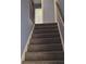Carpeted stairs leading to the upper level with wood railing and natural light at 851 Hedge Garden Ct, Stone Mountain, GA 30088