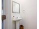 Cozy half bath with a pedestal sink, mirror, and towel ring at 1042 Edwin Ln, Sugar Hill, GA 30518