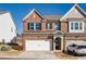 Charming brick townhome featuring a two-car garage and well-manicured lawn at 1042 Edwin Ln, Sugar Hill, GA 30518