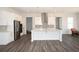 Bright kitchen showcasing white cabinets, stainless steel appliances, a large island, and wood-look flooring at 290 Brighton Bend Ln, Acworth, GA 30102