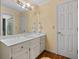 Bright bathroom with a white vanity, light countertops, a large mirror, and wood flooring at 440 Dix Lee On Dr., Fayetteville, GA 30215