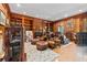 Cozy living room with a fireplace, wood paneled walls, bookshelves, leather seating, and hardwood floors at 440 Dix Lee On Dr., Fayetteville, GA 30215