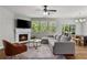 Comfortable living room features a modern fireplace, a sectional sofa and large windows at 1570 Lenox Overlook Ne Rd, Atlanta, GA 30329