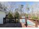 Stained wooden deck with decorative railing overlooking a pool and wooded backyard at 158 Lambeth Dr, Hiram, GA 30141