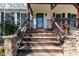 Inviting front porch with wood steps and stone support pillars at 158 Lambeth Dr, Hiram, GA 30141