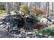 Backyard pond with decorative rocks, water feature, and surrounding landscaping at 158 Lambeth Dr, Hiram, GA 30141