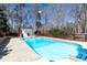 Outdoor swimming pool features clear blue water, concrete surround, pool house, and a wooden fence in a wooded setting at 158 Lambeth Dr, Hiram, GA 30141