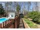 Inground pool surrounded by fence and mature trees, located near a pool house, creates a serene backyard retreat at 158 Lambeth Dr, Hiram, GA 30141