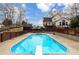 Backyard pool with diving board and surrounding brown fence; house in background with outdoor deck, sunny day at 158 Lambeth Dr, Hiram, GA 30141