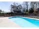 The backyard swimming pool, wooden fence, and home with deck create a private outdoor oasis for recreation and relaxation at 158 Lambeth Dr, Hiram, GA 30141