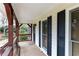 Inviting front porch with dark wood trim, ceiling, and windows at 158 Lambeth Dr, Hiram, GA 30141