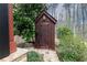 Exterior view of a backyard shed, featuring dark stained wood and a gabled roof at 158 Lambeth Dr, Hiram, GA 30141