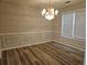 Bright dining room with decorative wainscoting, modern lighting, and wood-look flooring at 1822 Hayden Mill Ct, Lawrenceville, GA 30043