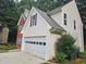 Side of the home and two car garage featuring vinyl siding, brick accents, and a well-maintained lawn at 1822 Hayden Mill Ct, Lawrenceville, GA 30043