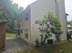 View of the side and back of the home, showing the vinyl siding and brick chimney at 1822 Hayden Mill Ct, Lawrenceville, GA 30043