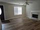Inviting living room with modern fireplace, ceiling fan, wood-look floors, and entry to dining room at 1822 Hayden Mill Ct, Lawrenceville, GA 30043