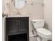 Neutral half bathroom features a dark vanity, a round mirror, and gray tile floors at 2275 Holly Run Dr, Jonesboro, GA 30236