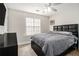 Bedroom featuring a large window, ceiling fan, and a bed with a tufted headboard and grey bedding at 2275 Holly Run Dr, Jonesboro, GA 30236