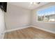 Empty room featuring a large window with blinds, wood-look flooring, and neutral colored walls at 2275 Holly Run Dr, Jonesboro, GA 30236