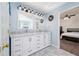 Bathroom featuring double sinks with marble countertop on white cabinets and a door leading to a bedroom at 3876 Toccoa Falls Dr, Duluth, GA 30097