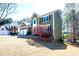 A charming home featuring a well-manicured lawn with a decorative tree and a tranquil pond in the background at 3876 Toccoa Falls Dr, Duluth, GA 30097