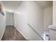 Second floor hallway with gray wood-look flooring and a staircase with a metal handrail leading to the first floor at 3876 Toccoa Falls Dr, Duluth, GA 30097