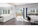 Bright living room with sliding glass doors to deck, wood floors and white sofa at 3876 Toccoa Falls Dr, Duluth, GA 30097