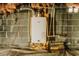 Basement with a hot water heater, brick walls, and a new bag of Quickrete 5000 at 494 Rue Montaigne, Stone Mountain, GA 30083