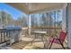 Covered back porch with a grill, table, and chair, perfect for outdoor dining and relaxation at 115 Laurelwood Ln, Dallas, GA 30157